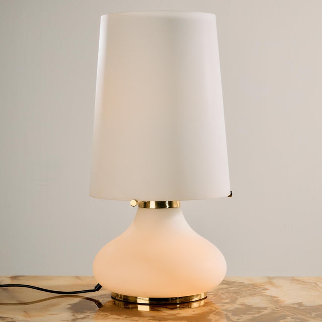 Limburg table lamp with brass details from the 1960s. The lamp’s shade and body are made of opaline glass, making it an...