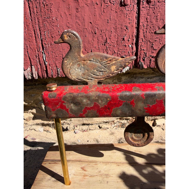 A fabulous mottled carnival red case highlights this surviving pair of cast iron shooting gallery ducks with strong carved...