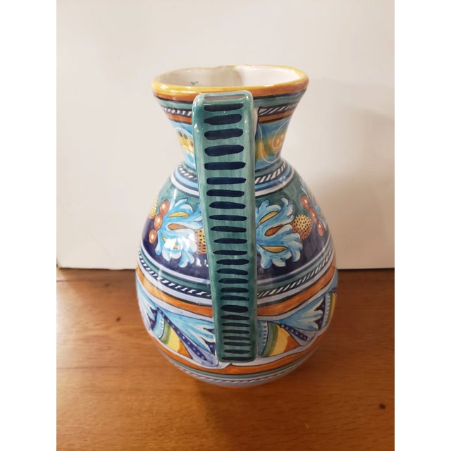 This is a Circa 1970 Italian Deruta Ware Faience Pottery Stamped Pitcher, Made in Italy. It measures 14 3/8" high, 9 1/2"...