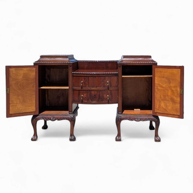 A striking antique English Georgian Revival sideboard crafted in richly toned mahogany, dating to the early 20th century....