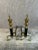 Vintage pair of French Empire or Regency Style brass and black cast iron, steeple top andirons with lion’s paw feet. This...