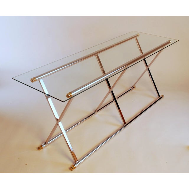 Beautiful vintage console or hall table. Shiny chrome finish with brass color end finials. base is 15”x56”x24.75”. Glass...