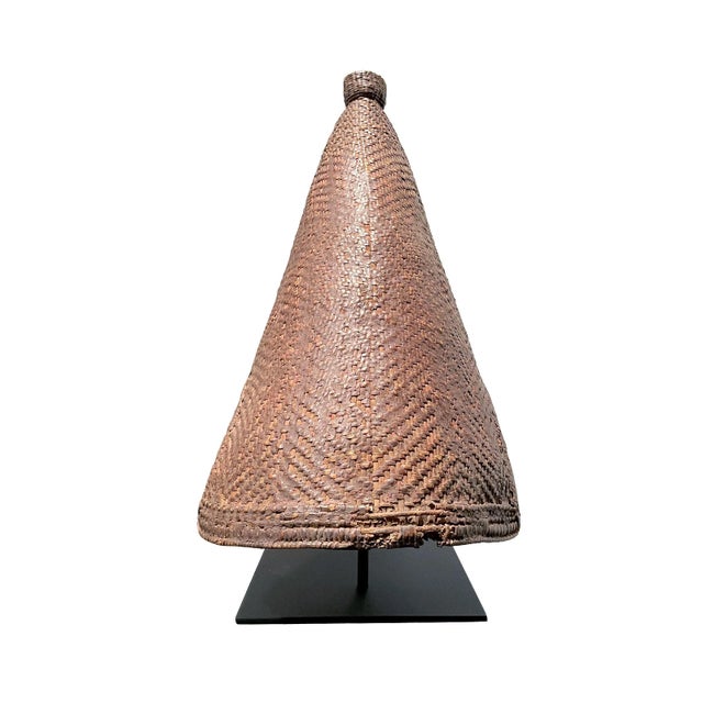 A thickly woven rain hat worn by women of the Lugbara and Mangbetu tribes. Tight and intricate weaving topped with a woven...
