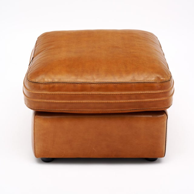 Ottoman from mid-century France by renowned furniture brand Roche Bobois. This piece is made of camel colored leather with...