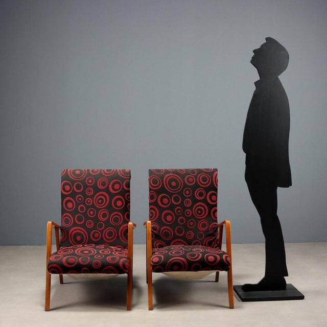 Pair of armchairs, exposed beech wood, spring and foam padding, fabric upholstery. Requires restoration. This piece is...