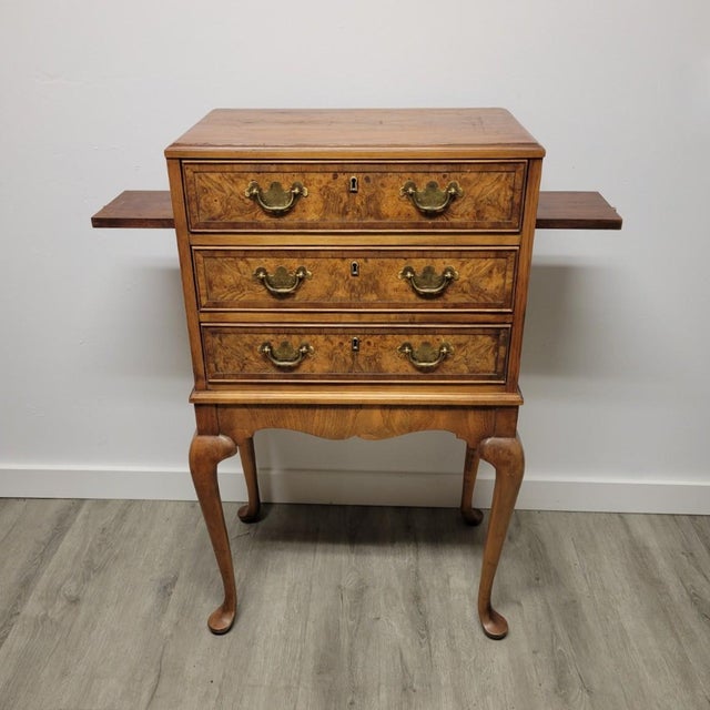 A finely proportioned silver flatware chest by Hekman, crafted with an oak case and richly figured walnut burl drawer...