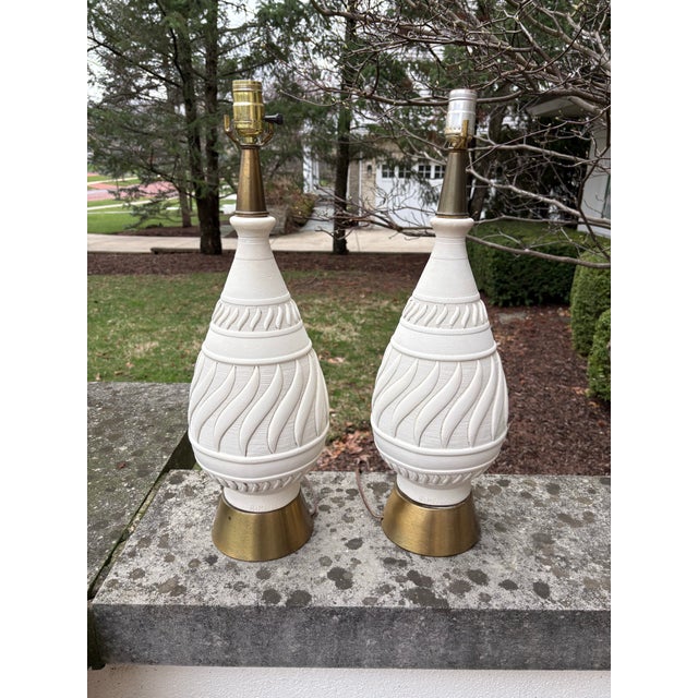 Pair of Plasto manufacturing lamps. They are made of plaster but appears to be painted over in a creamy white.
