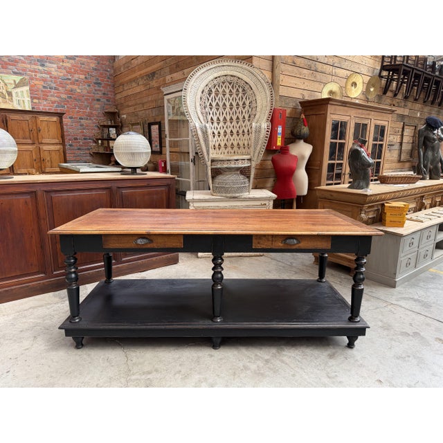 This antique oak draper's table has been fully restored. It features a waxed wooden top and a black-patinated base. The...
