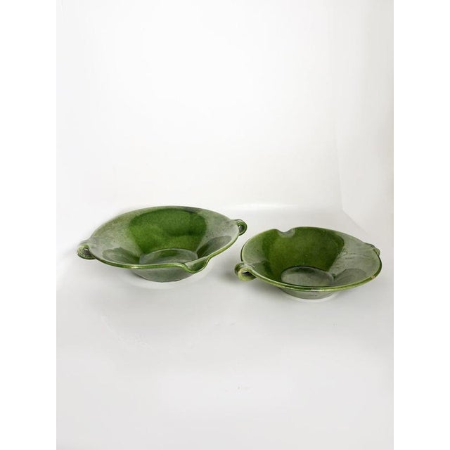 Charming pair of French ceramic bowls dating from the 1960s, featuring a rich green glazed finish with subtle variations...