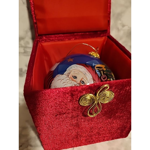 This is a large glass ornament. It is reverse painted, featuring Santa with his bag of Christmas toys. Box included.