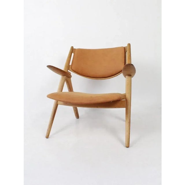 Armchair Sawbuck CH28 designed by Hans J Wegner for Carl Hansen, produced 70's Denmark. The frame of the chair is made of...