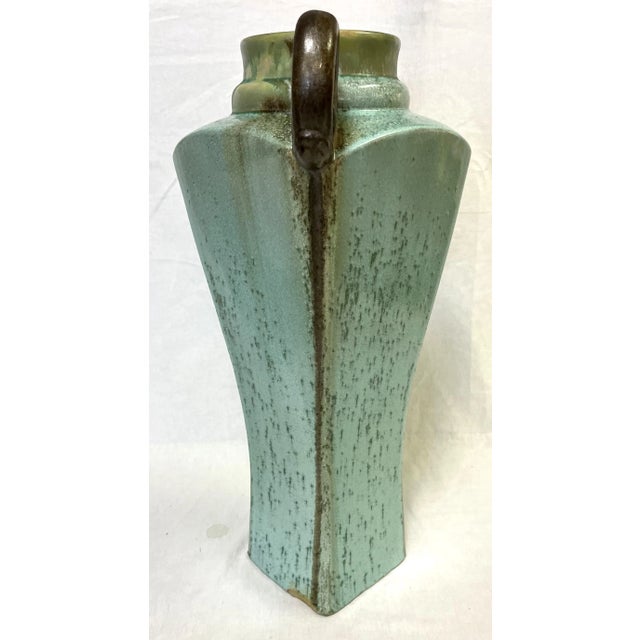 Monumental ceramic vase with an amphora shape and dramatic curved handles. The stunning piece is finished with a dynamic...