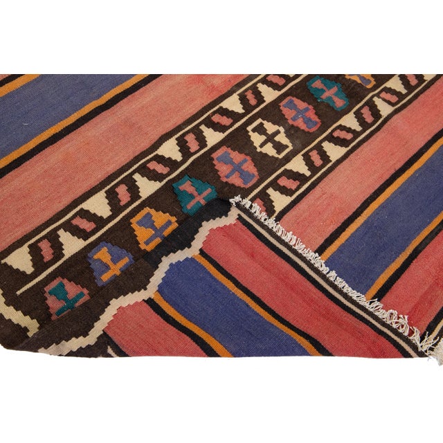 Beautiful vintage Turkish Kilim hand-knotted wool rug with a peach field. This piece has a beige frame and multicolor...