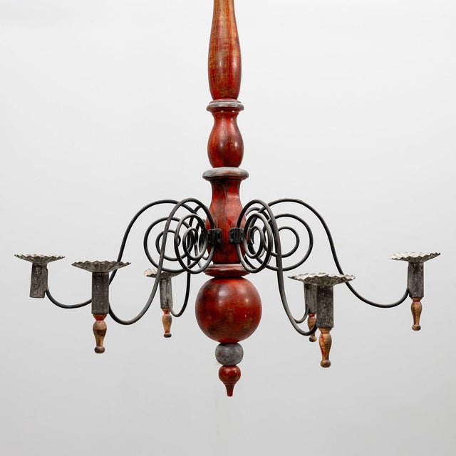 Five-arm chandelier with a hand-turned wood body in original barn red paint and hand-forged wrought iron arms that curl...