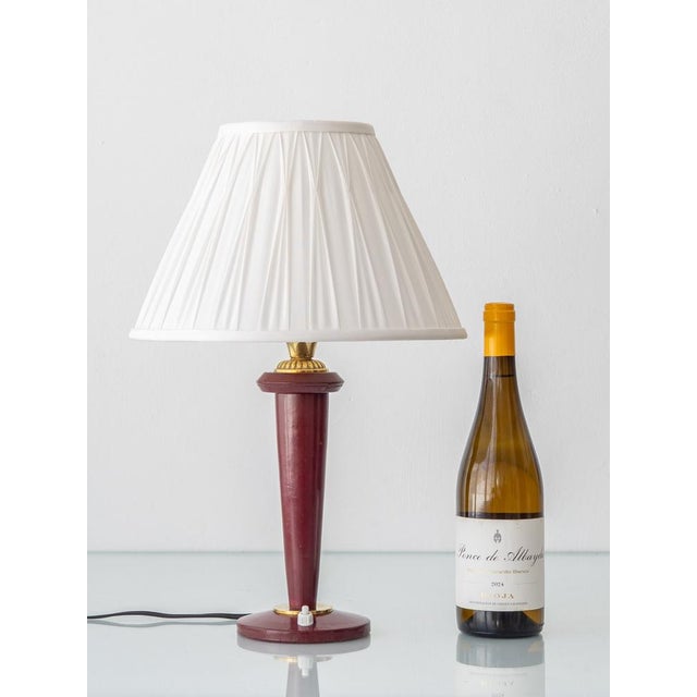 Maison Lancel French table lamp in burgundy leather with brass details, circa 1940s–1950s, newly fitted with a white silk...