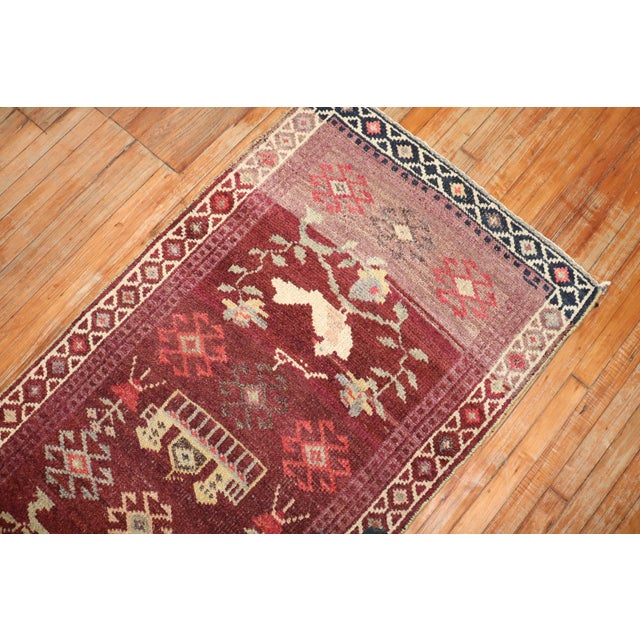 Turkish Anatolian runner featuring three white pigeons on a plum-colored field. Measures: 3'1'' x 11'3''.