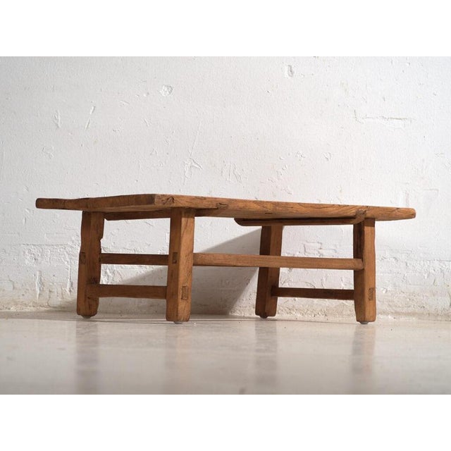 Chinese low table in solid elm wood, dating from around 1900, conceived as a functional piece within traditional domestic...