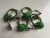 Lovely set of 8 mismatched silver polished aluminum pear and green glass beaded rosette flower napkin rings. Gorgeous...