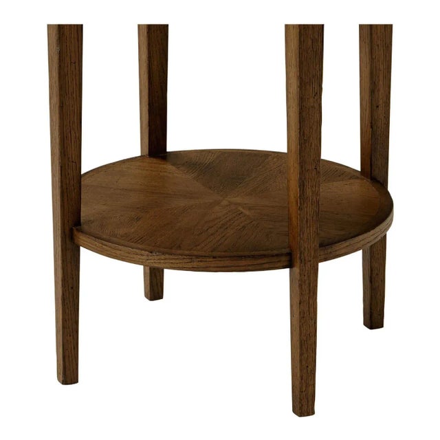 A dark oak parquetry round side table with tapered oak legs. This beautiful round two-tier side table has an arranged...