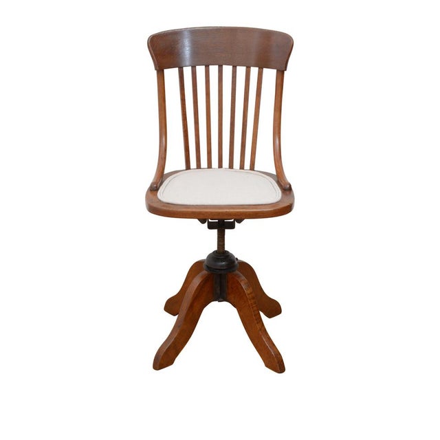Unusual early 20th century, revolving and height adjustable chair in oak with shaped top rail, slatted back and newly...