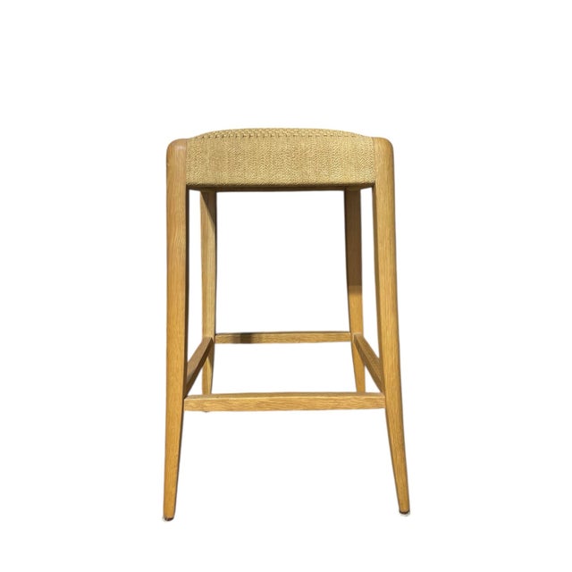McGuire Furniture Counter stool or bar stool featuring tapered wooden legs and woven, caned seat top. 21st Century