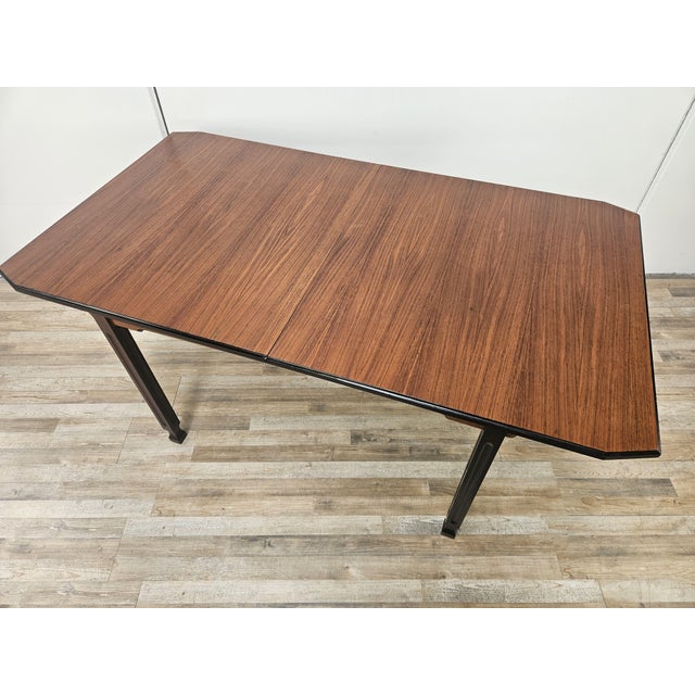 Walnut table with ebony legs and details, Italian production from the 70s. It can be extended to comfortably accommodate...
