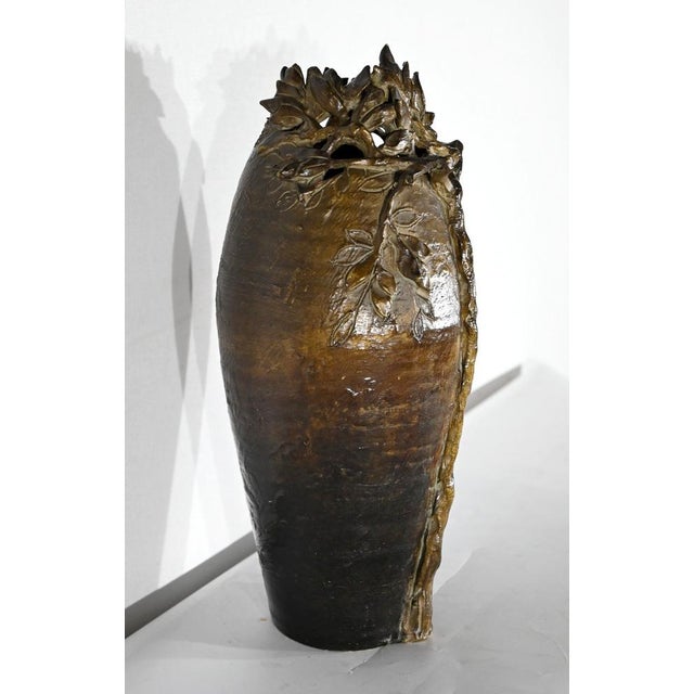 Ceramic vase of ogival shape, representing a tree in relief on a green and slightly ochre background. the lip, openwork,...