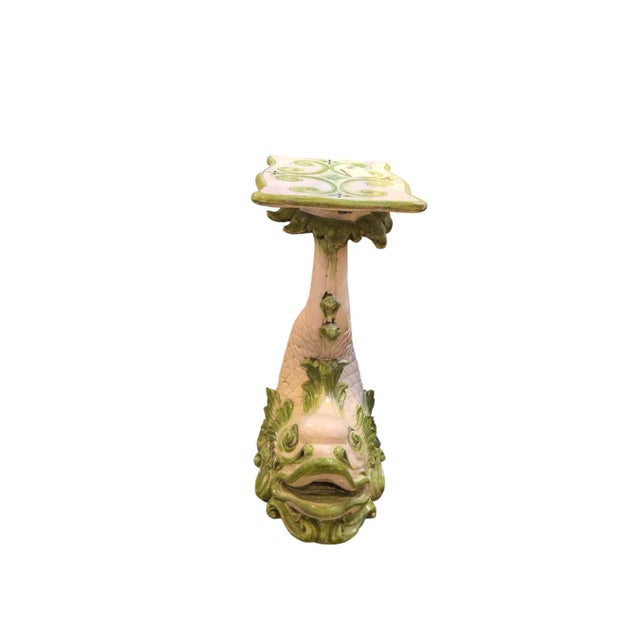 An Italian ceramic glazed dolphin pedestal with intricate fine and scale details, completed with a rectangular top...