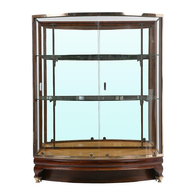 Business showcase in brass and mahogany. It rests on four brass feet with skids, has a mahogany plinth designed to let...