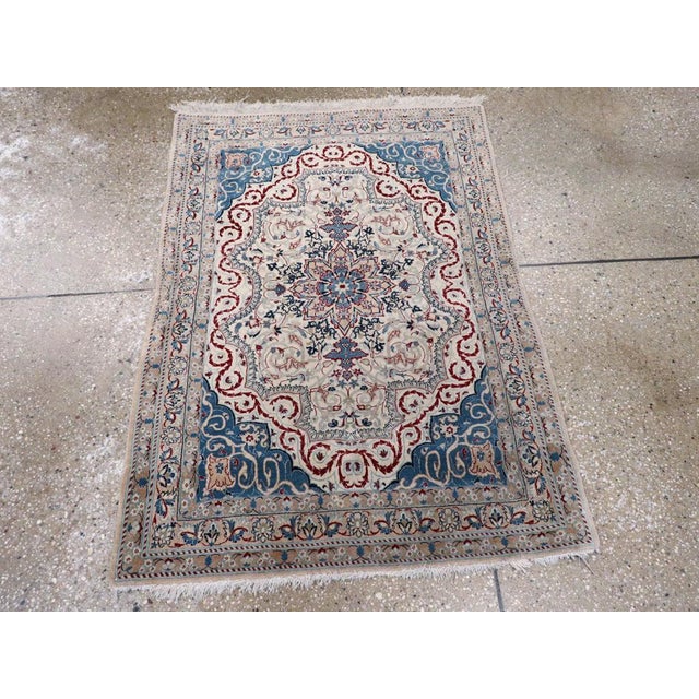 A vintage Persian Nain throw rug. The production of Nain rugs in central Persia began in the late 1930’s. This example,...