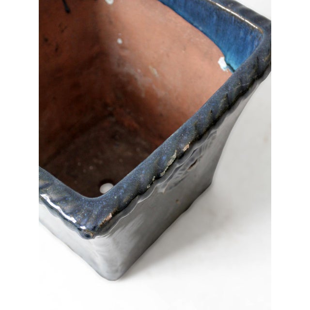 This substantial vintage art pottery planter is defined by its flared square form, sculpted rosette medallions, and richly...