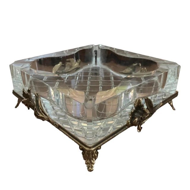 Highly decorative crystal ashtray with cut checkerboard base sits atop a gold metal frame on scroll legs and flower...