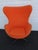 This vintage Egg-style lounge chair features a striking orange upholstered shell with a sturdy metal swivel base. Inspired...