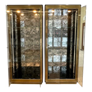Vintage Hollywood Regency Mastercraft Pair of Illuminated Brass Glass Curio Cabinet Showcases W/ Antiqued Mirror Back For Sale