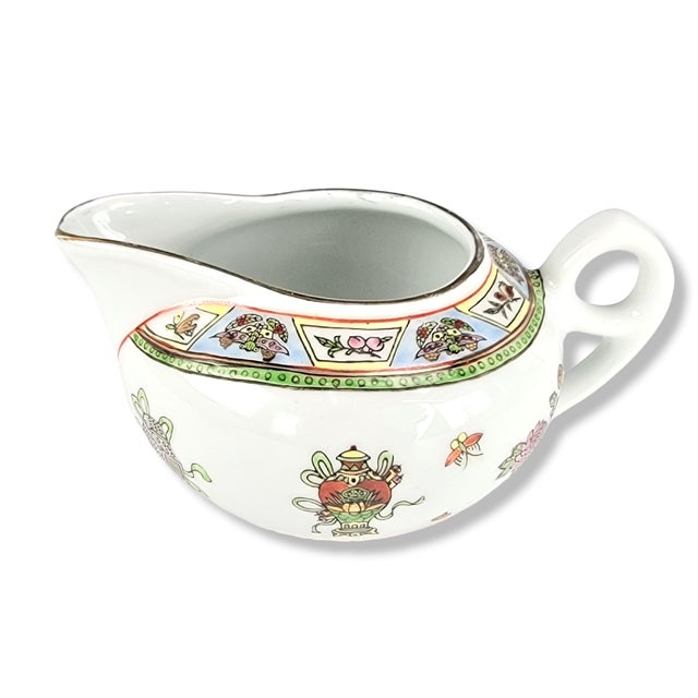 This Jingdezhen porcelain creamer is decorated in Guangcai style, featuring overglaze Famille-rose enamels with gilt...