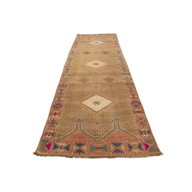 This lovely vintage Turkish Kars hand-knotted wool rug has a tan-colored field. It showcases a stunning Tribal design with...
