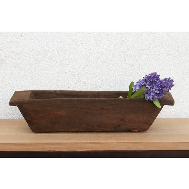 Carved from a single, massive log of hardwood, this antique wooden trough was likely originally used in a village setting...