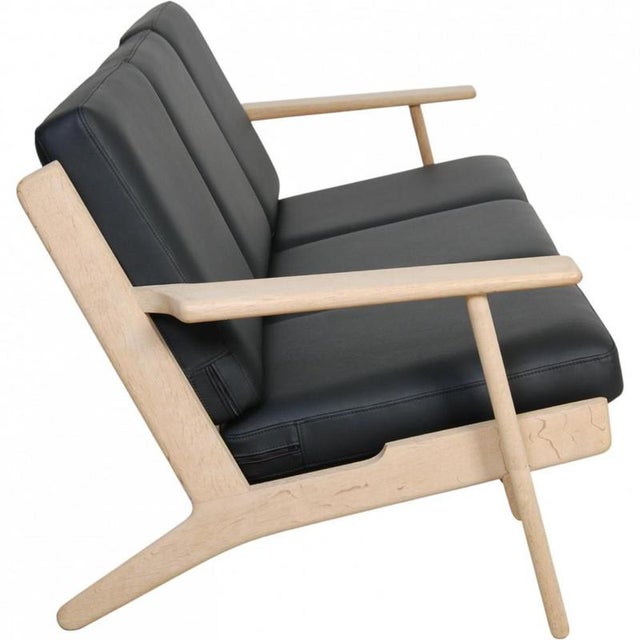 Hans Wegner 3-seater sofa model GE290 with a frame of soap-treated oak and new foam cushions upholstered in black bizon...