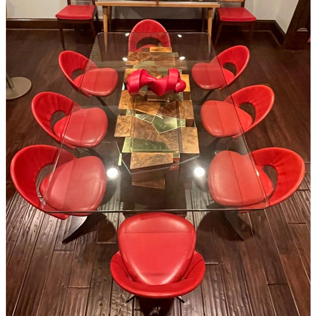 A set of sculptural pedestal chairs in black enamel steel frame and red leather upholstery designed by Spanish architect...
