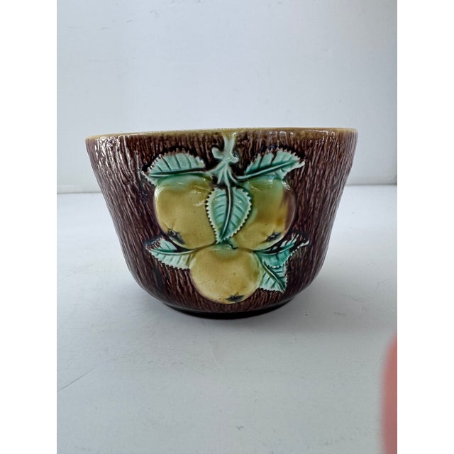 A newer majolica piece depicting orchard fruits. Wonderful brown glaze on the exterior in a bark like pattern. The...