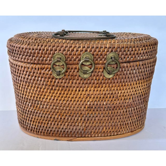 Antique Chinese wicker lunch basket lined with lovely floral fabric. Has double handles on the top, 3-ring hinge at the...