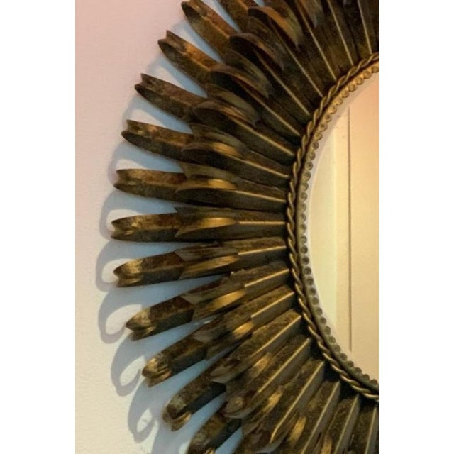 Large oval starburst mirror in gilded and crafted iron. Made in France, mid-1900s. In beautiful condition, smaller signs...