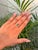 This elegant floral cluster engagement ring features a 1.06 carat emerald-cut natural emerald, securely set in a classic...