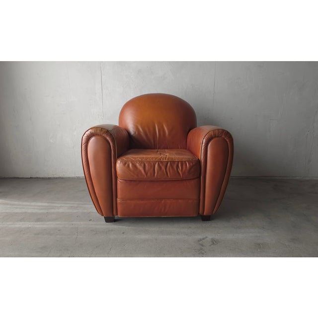 Beautiful vintage leather club chair inspired by classic European Art Deco design. The chair is oversized, featuring a...