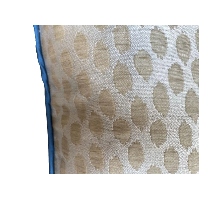This pillow features a soft, textured fabric with a subtle, dotted brushstroke pattern in warm beige tones, adding depth...