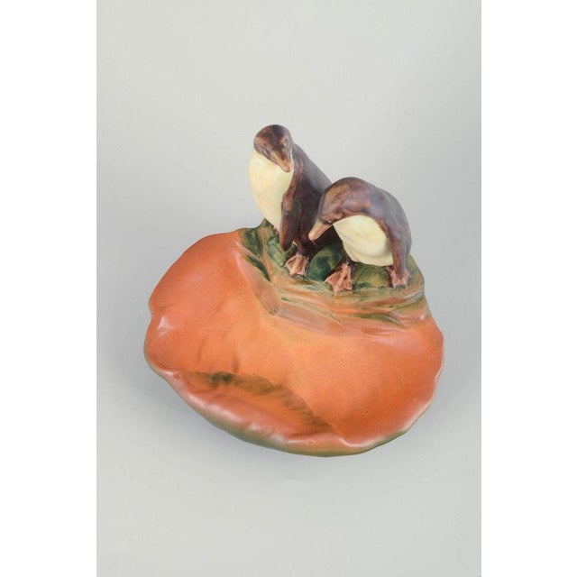 Ipsens Enke Decorative dish, 1920s/30s. Figurative glazed ceramic dish featuring two penguins standing beside a basin-...