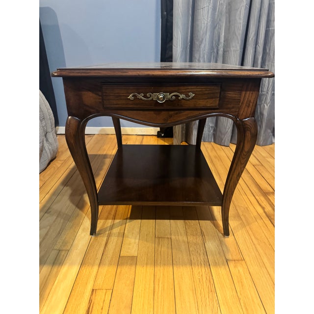 Authentic Henredon walnut side table featuring elegant cabriole legs, a lower shelf, and a decorative brass-handled...