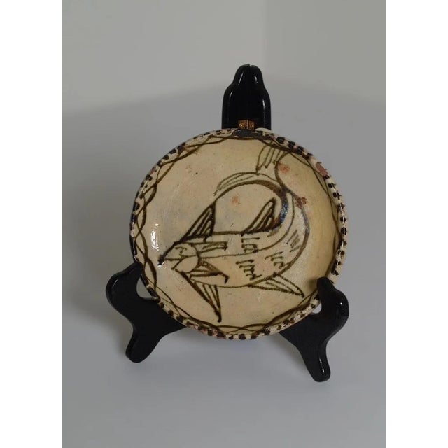 Handcrafted pottery plate from Tzintzuntzan, Michoacán, Mexico, featuring a stylized fish motif in traditional black-on-...