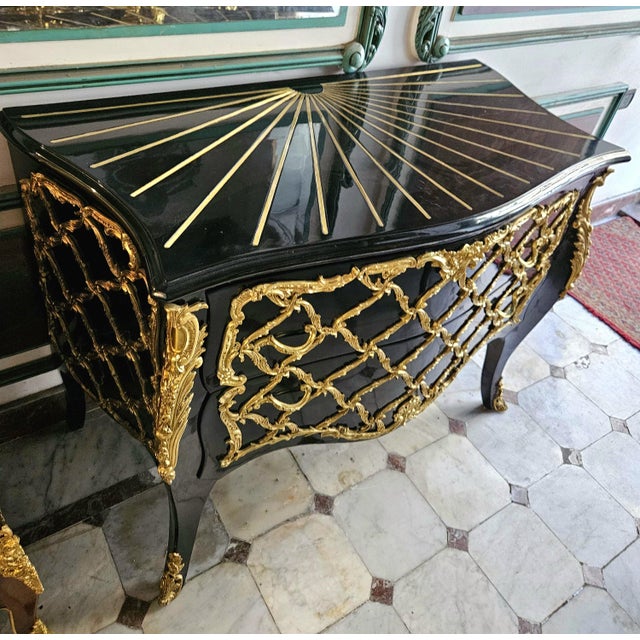 Make a bold statement with this striking black French Boulle-inspired commode, distinguished by its dramatic curved...