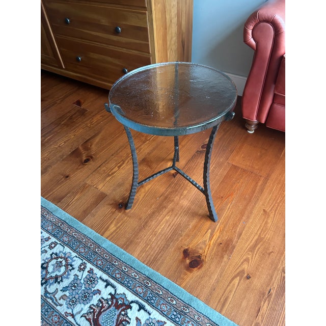 The Charleston Forge Cascade Drink Table features a trio of hand-hammered iron legs that come together to support the top,...